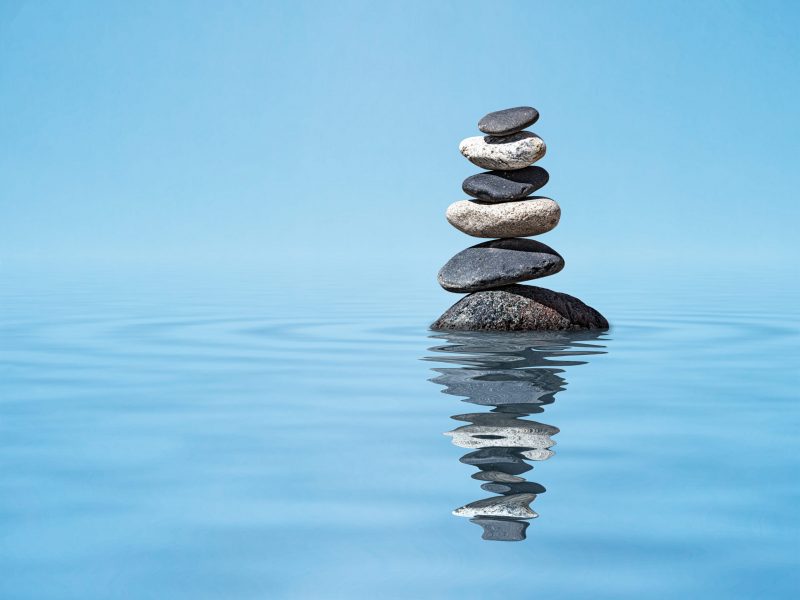 Zen harmony meditation relaxation peacefulness peace of mind concept background -  balanced stones stack in water with reflection